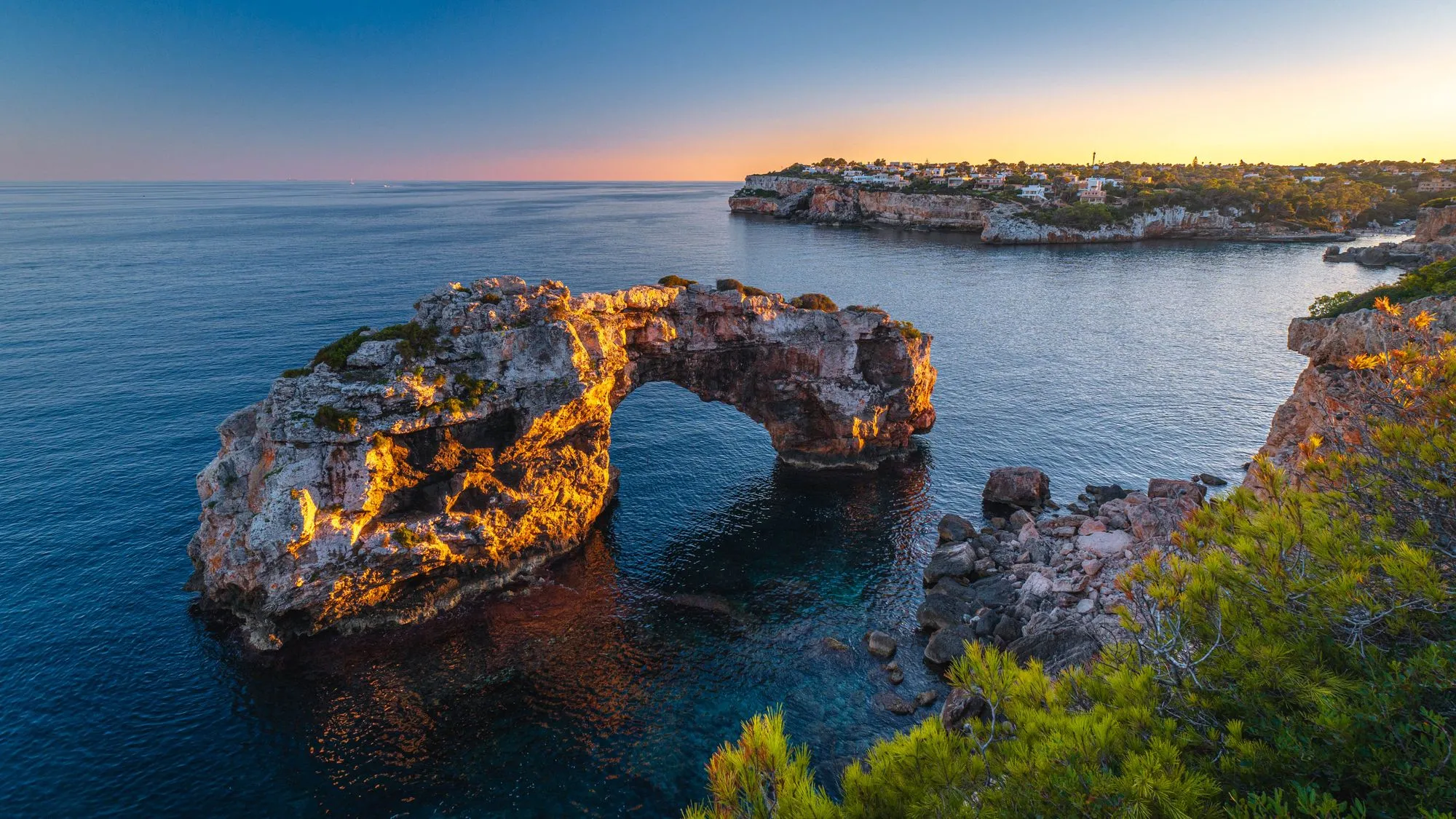 De natuurlijke rotsboog Es Pontàs op Mallorca bij zonsondergang