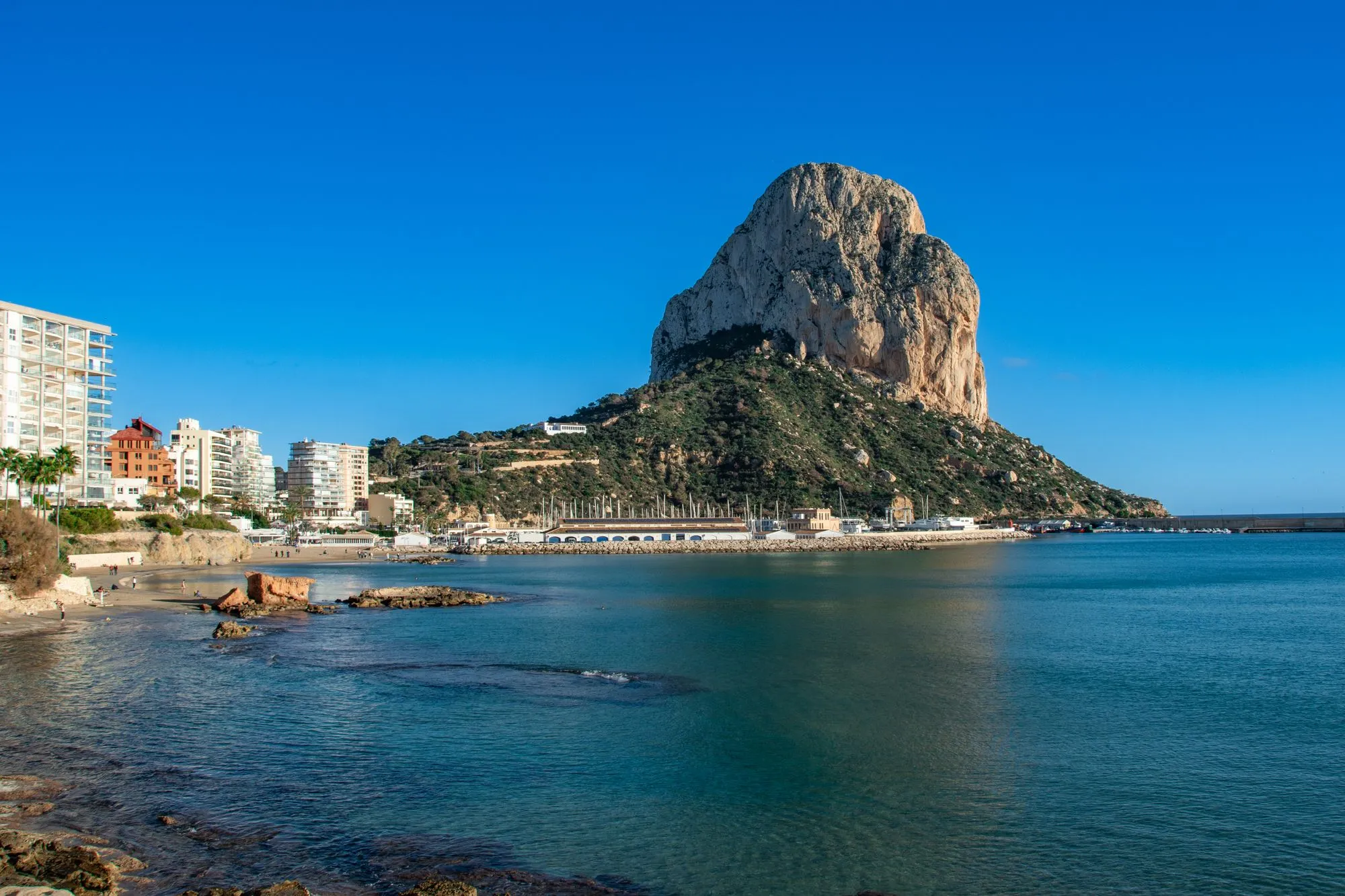 De Peñón de Ifach boven de kust en de huizen van Calp